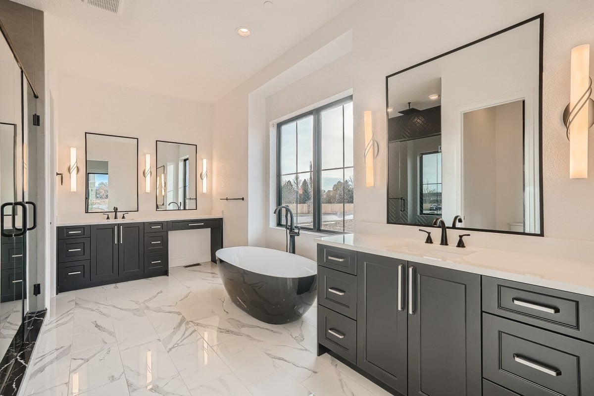 Luxurious bathroom featuring a bowl-shaped freestanding tub and dual vanities in a home by Sheffield Homes in Westminster, CO