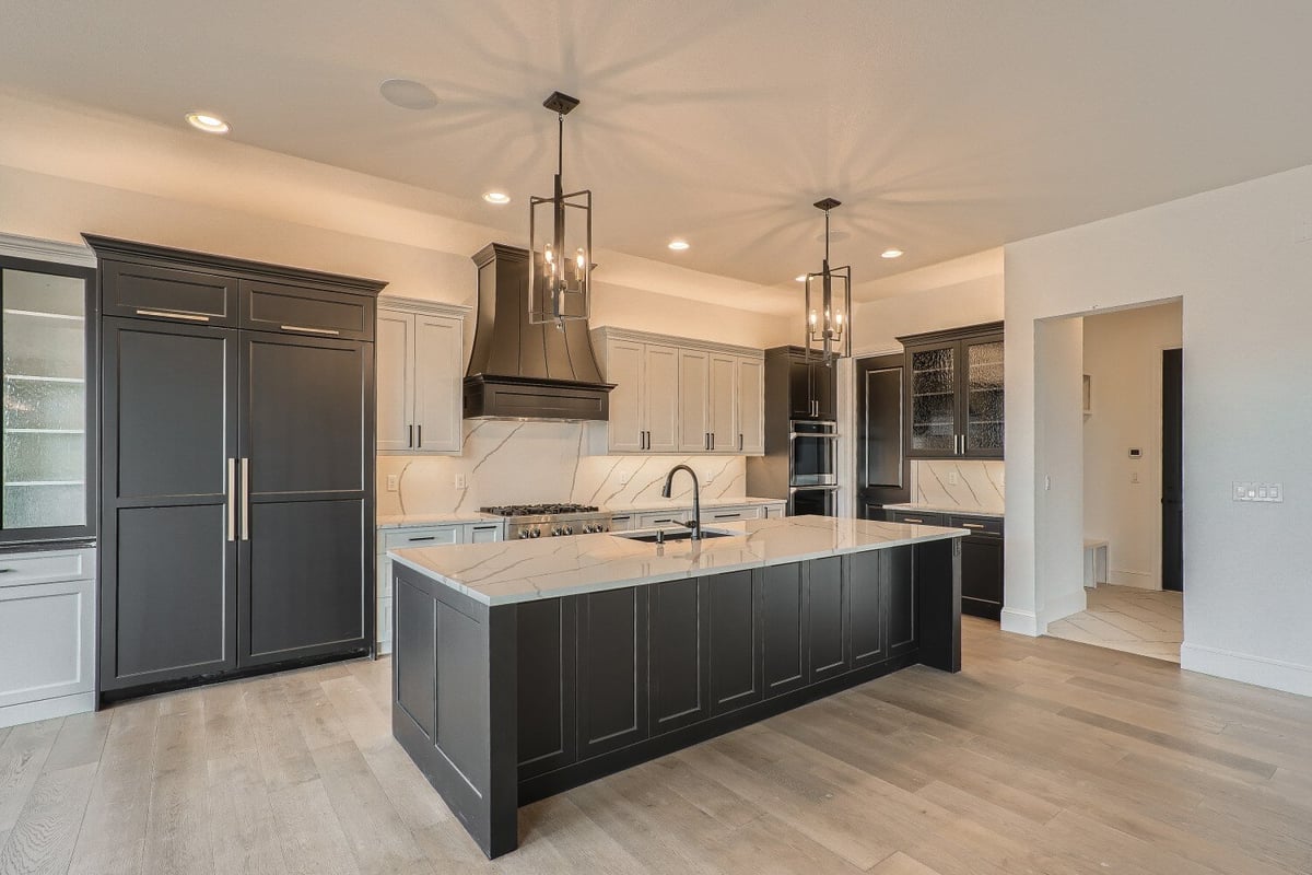 Modern kitchen with a central island, elegant pendant lights, and wooden cabinetry in a Sheffield Homes home, Westminster, CO