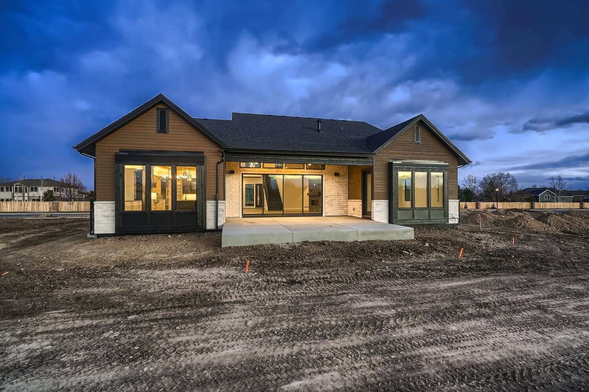 Rear exterior view of a large custom home with a patio and a covered backyard fence, by Sheffield Homes in Westminster, CO