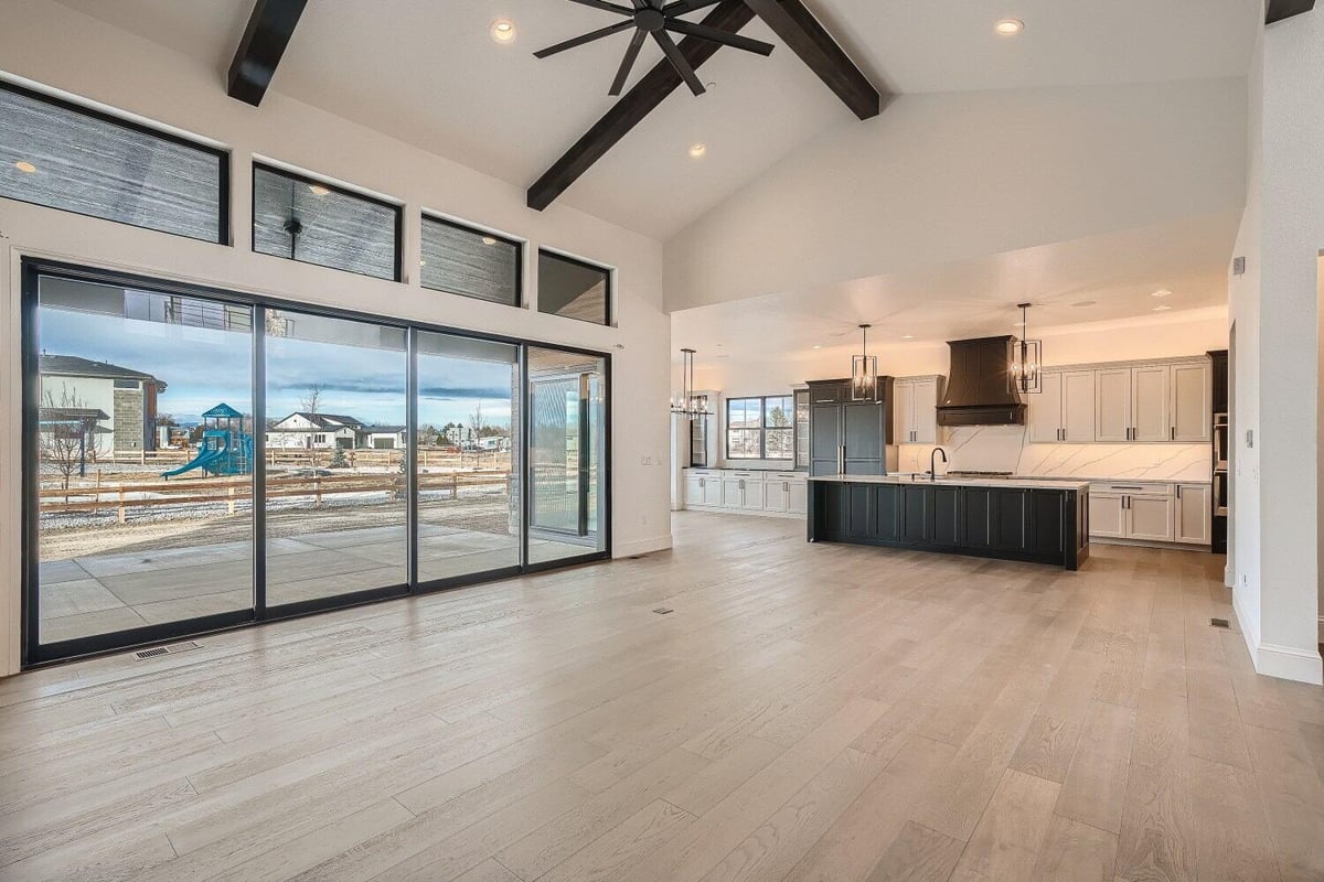 Spacious living room with an open-concept kitchen and large sliding main doors in a Sheffield Homes home in Westminster, CO