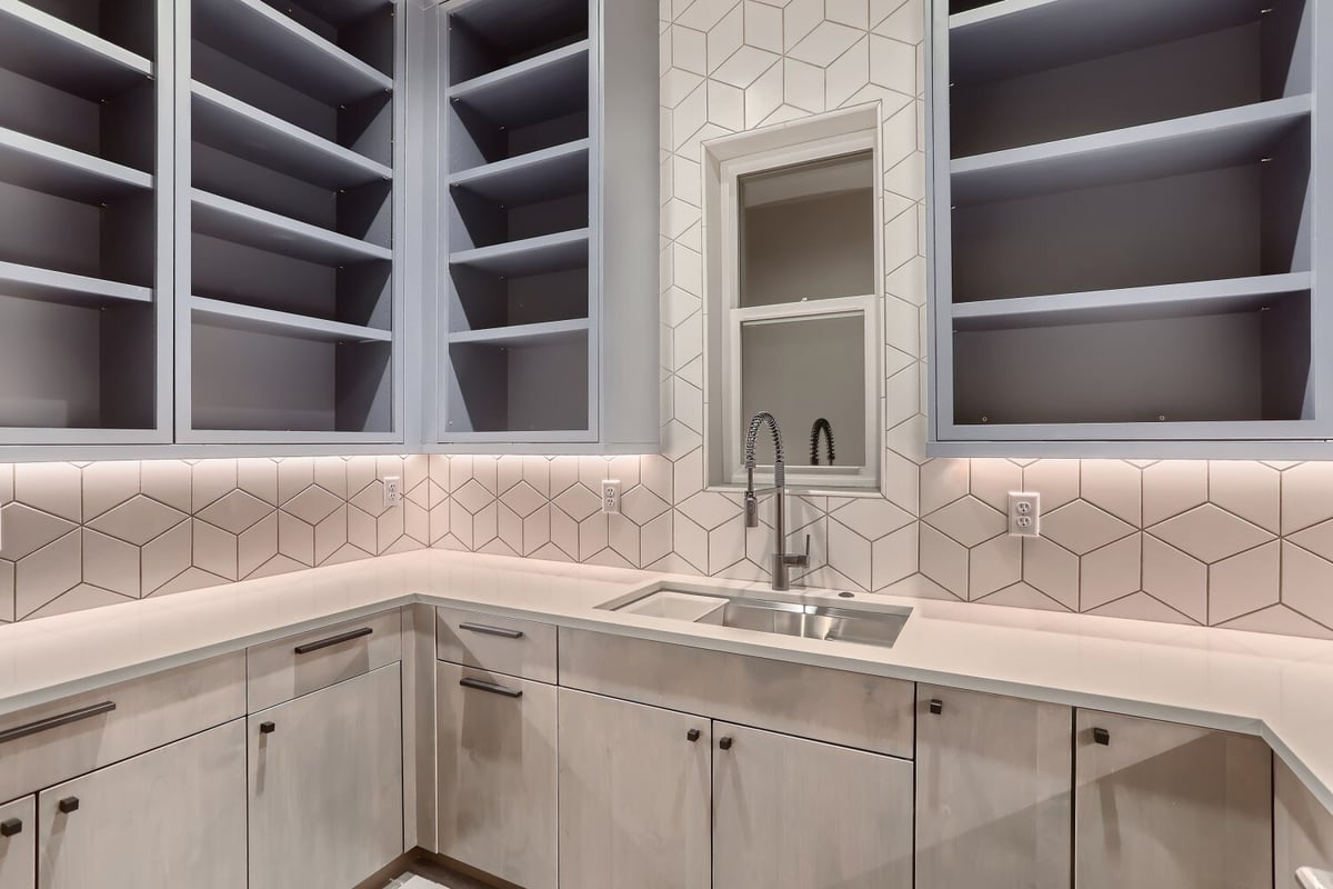 Kitchen counter featuring a sink, cabinetry, and wooden storage slots on the top in a Sheffield Homes home in Westminster, CO