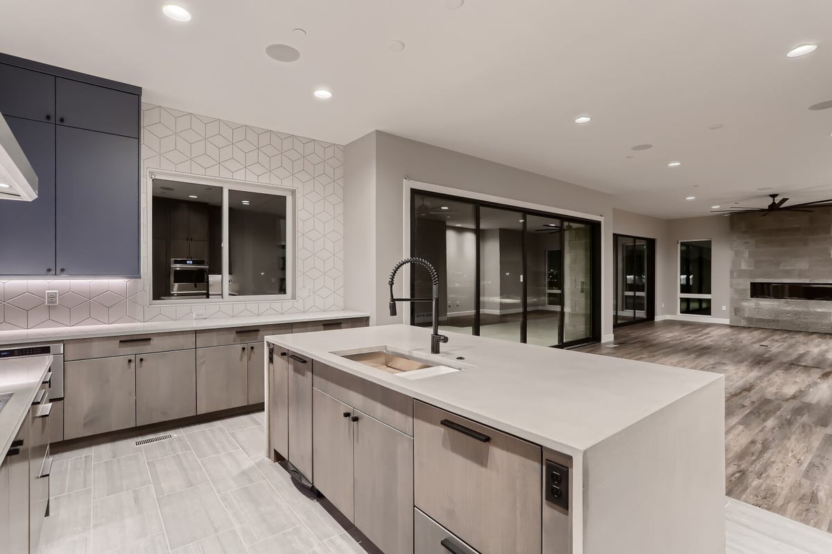 Kitchen island with a sleek countertop, flexible faucet, and some cabinets and drawers, by Sheffield Homes in Westminster, CO