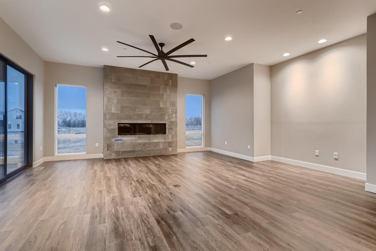 Living room with vinyl flooring, a fireplace, ceiling fan, and recessed lighting in a Sheffield Homes home in Westminster, CO