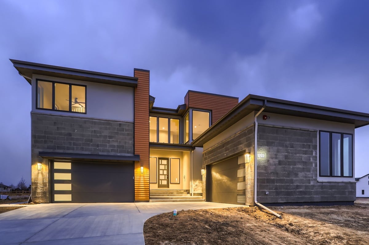 Low-light exterior front view of a custom home with elegant design and lighting, built by Sheffield Homes in Westminster, CO