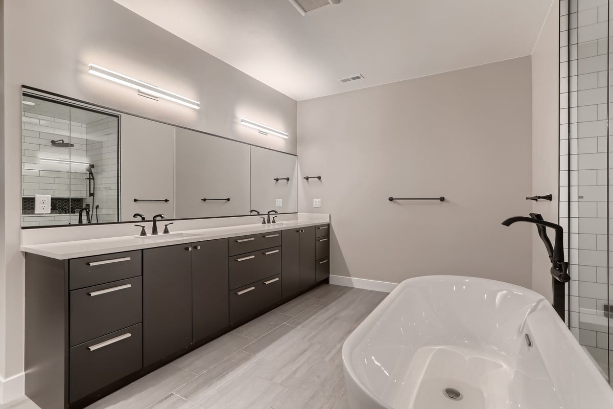 Primary bathroom featuring a bathtub with a standing faucet and a dual vanity in a Sheffield Homes home in Westminster, CO