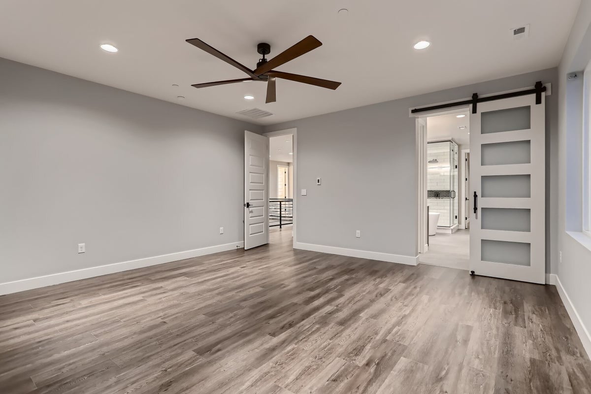 Primary bedroom with vinyl flooring, featuring an access door and a bathroom door, in a Sheffield Homes home, Westminster, CO