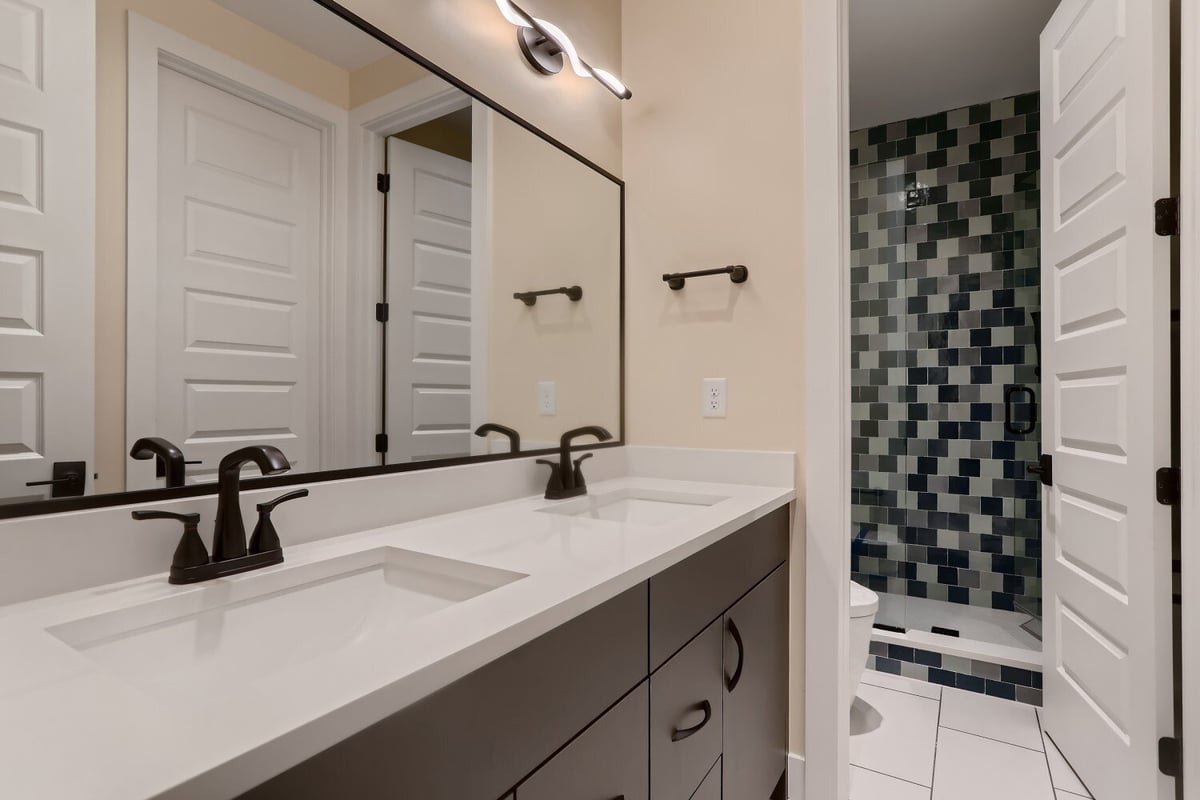 Second-floor bathroom with a stylish dual-faucet vanity and a separate shower room, by Sheffield Homes in Westminster, CO