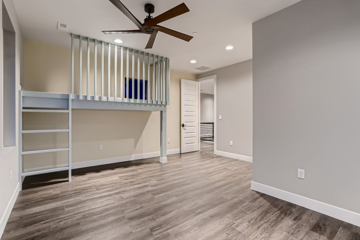 Second-floor bedroom with vinyl flooring and a lofted area accessed by wooden steps, by Sheffield Homes in Westminster, CO