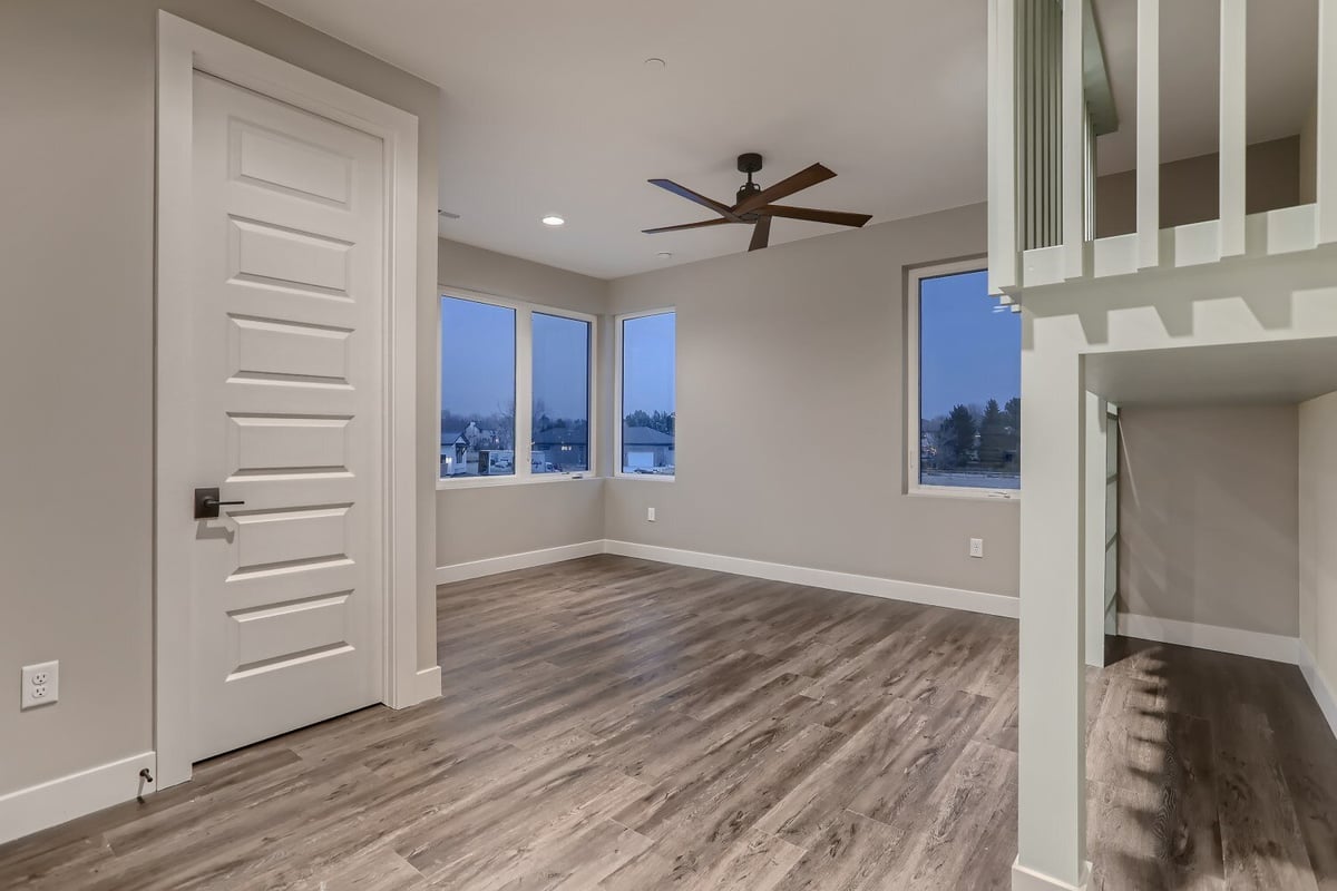 Second-floor bedroom with vinyl flooring and a lofted area on wooden pillars in a Sheffield Homes home in Westminster, CO