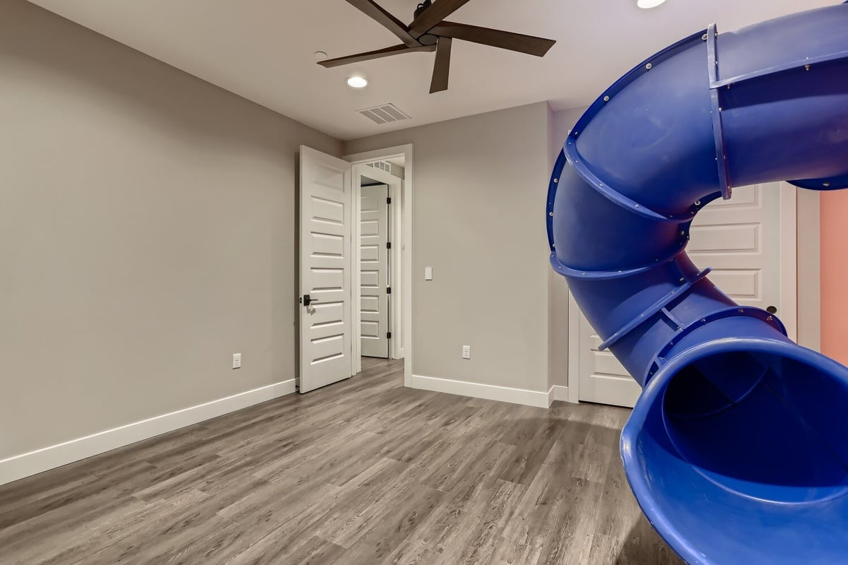 Second-floor bedroom with vinyl flooring and a rounded home slide exit point in a Sheffield Homes home in Westminster, CO