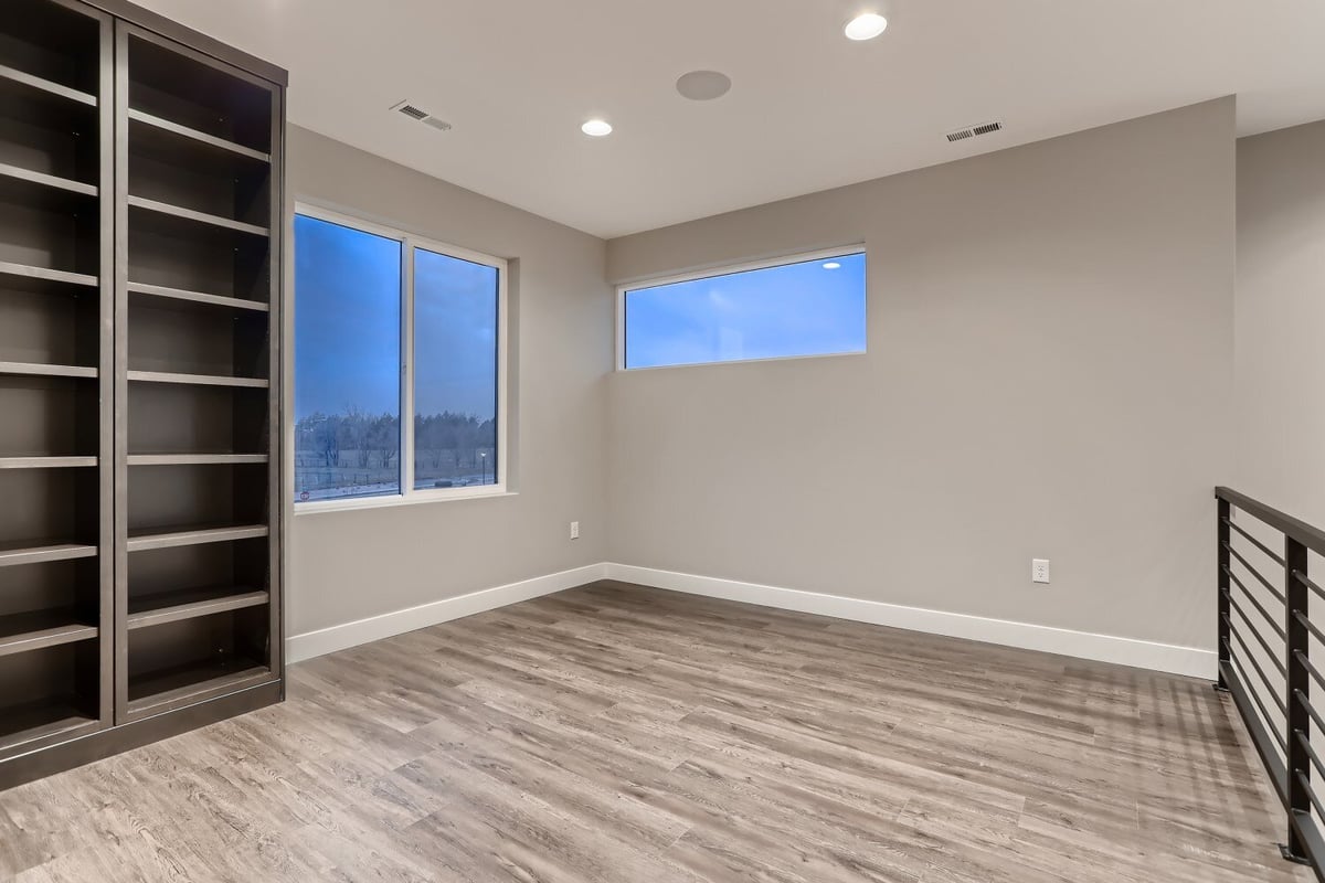 Second-floor loft area with vinyl flooring and a wooden closet next to a window in a Sheffield Homes home in Westminster, CO