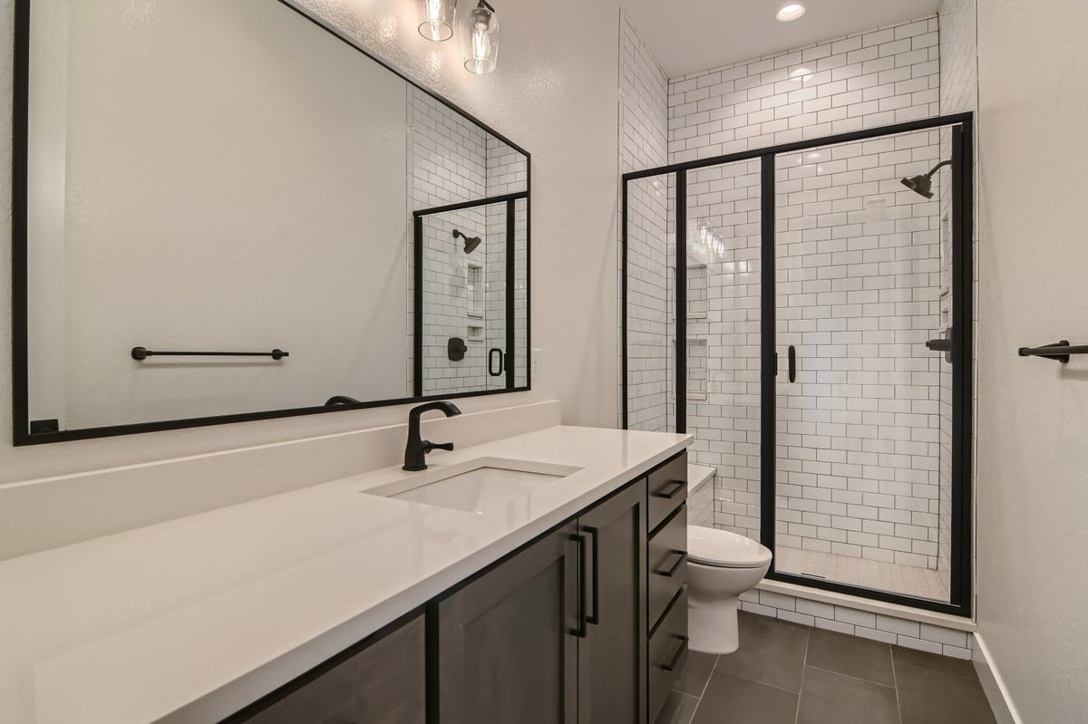 Bathroom featuring a vanity, a toilet, and a corner glass-enclosed shower room in a Sheffield Homes home in Westminster, CO