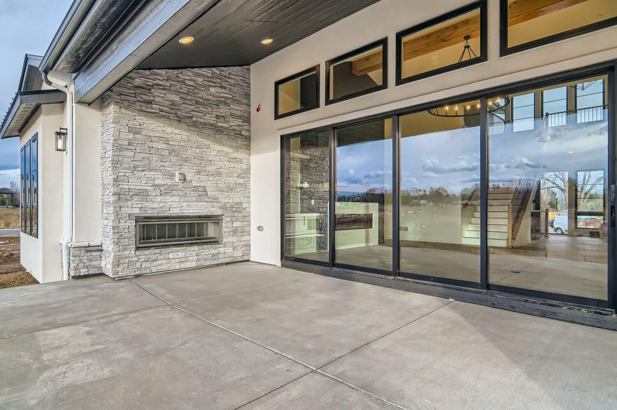 Custom patio with black glass doors leading from the living room in a custom home by Sheffield Homes in Westminster, CO