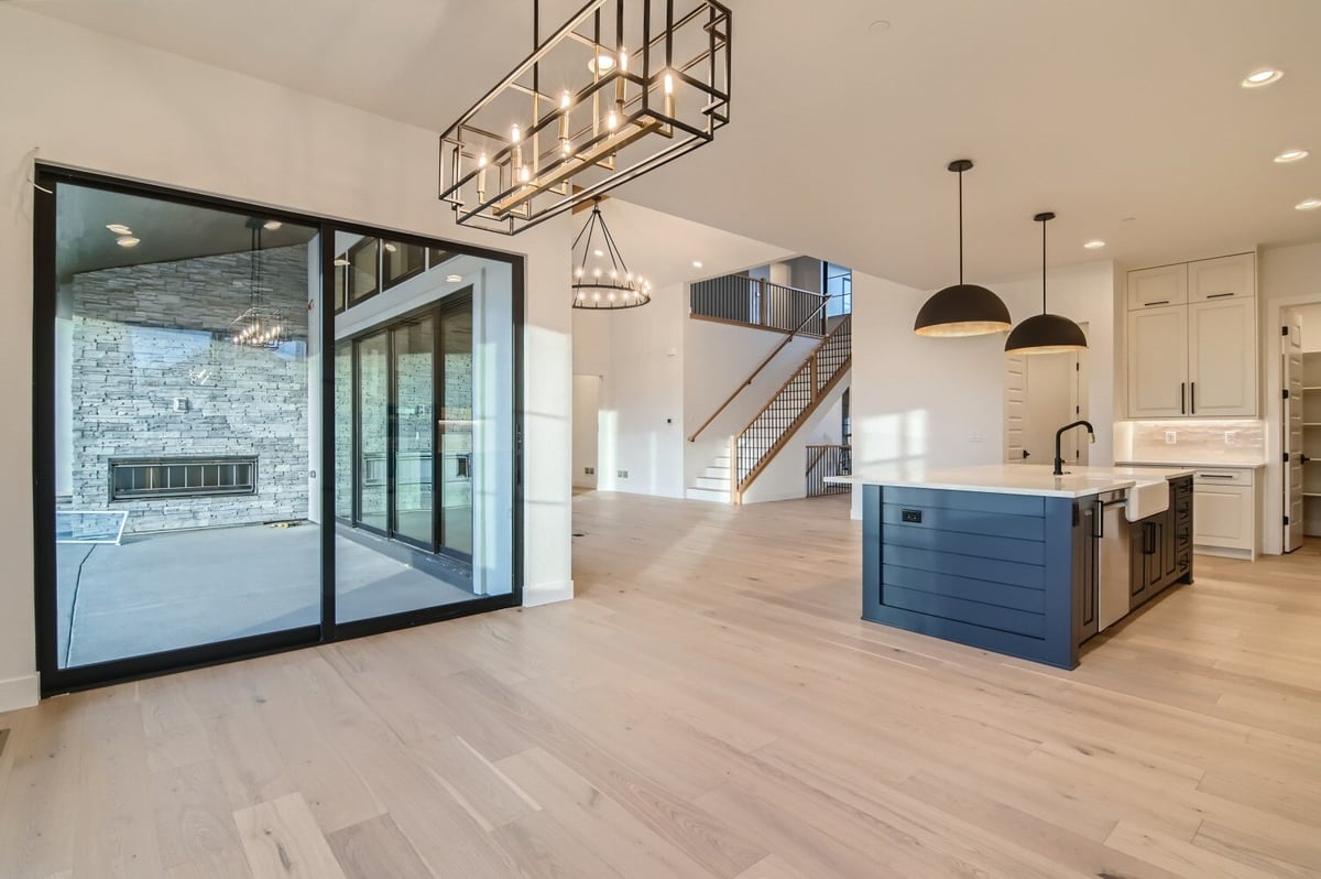 Dining room with a stylish chandelier and a door leading to a custom patio in a Sheffield Homes home in Westminster, CO