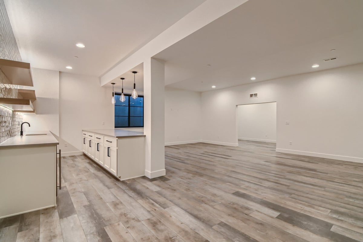 Lower-level dining room with vinyl flooring, adjacent to the kitchen in a custom home by Sheffield Homes in Westminster, CO