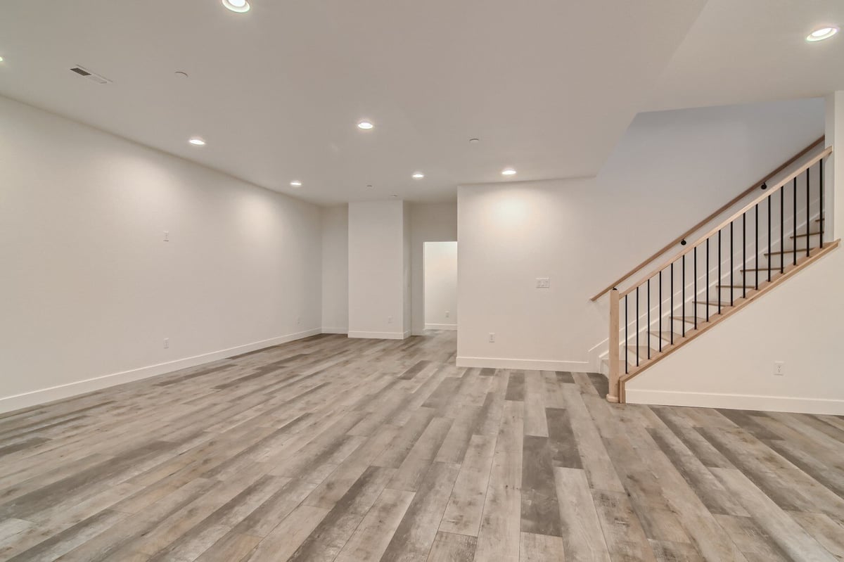 Lower-level family room with vinyl flooring and recessed lights, perfect for activities, by Sheffield Homes, Westminster, CO