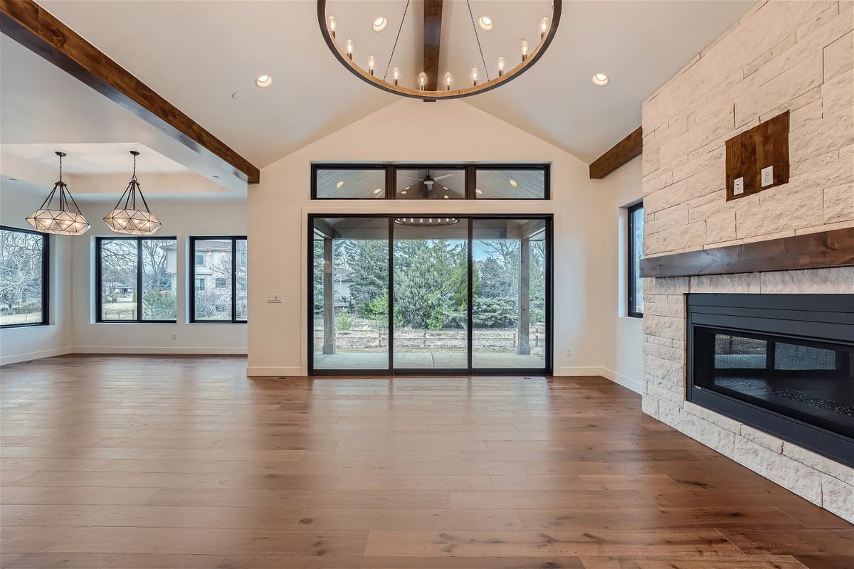 Bright living room with multiple chandeliers for added elegance and large main doors by Sheffield Homes in Westminster, CO