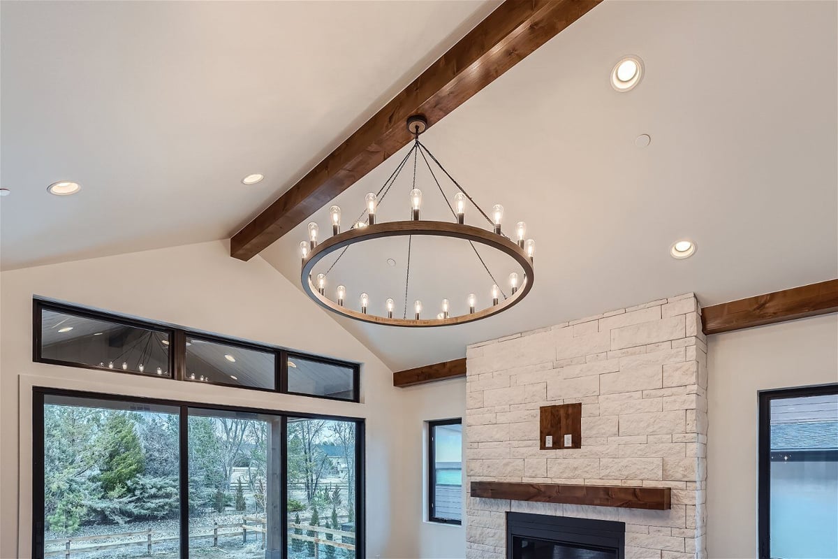 Chandelier with lit bulbs in the living room for added elegance, by Sheffield Homes in Westminster, CO