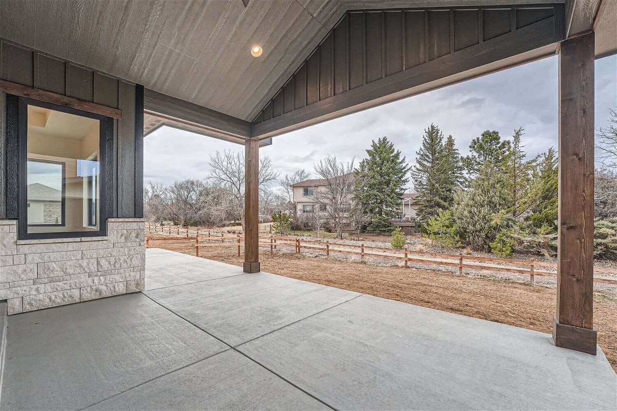 Custom patio for outdoor views with a wooden hood and pillars, by Sheffield Homes in Westminster, CO