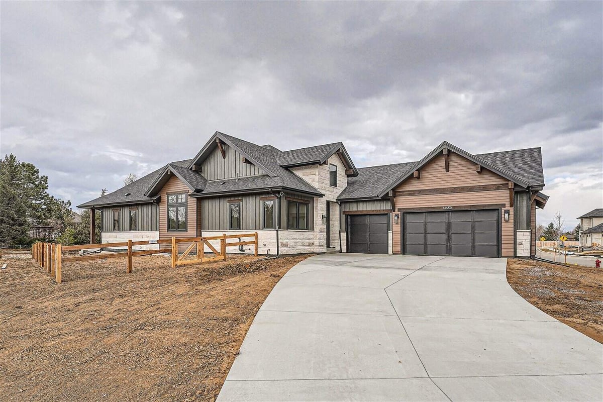 Daylight exterior front view of a custom home with a yard, garage, and paved driveway, by Sheffield Homes in Westminster, CO