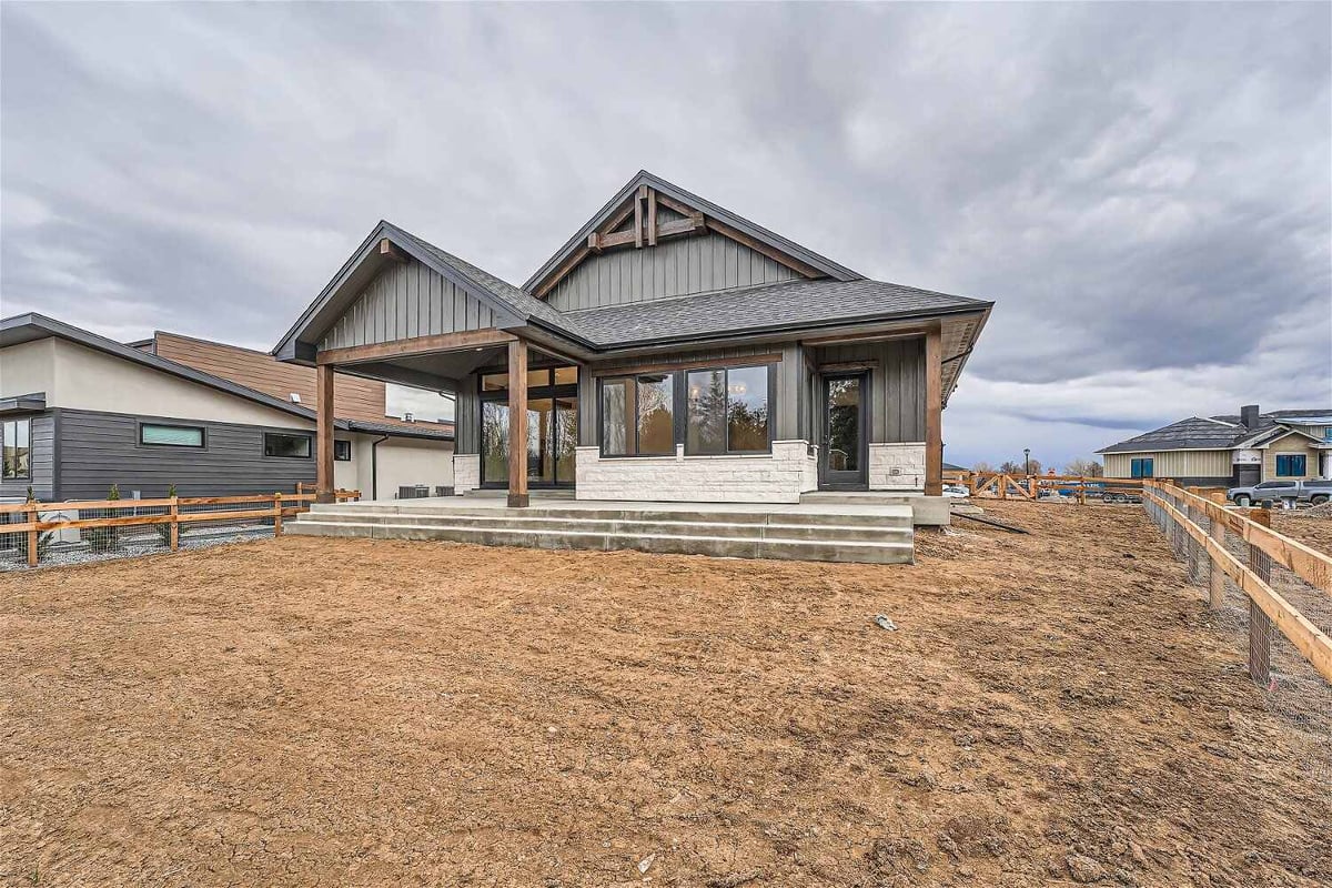 Daylight exterior rear of a custom home with a boundary-covered backyard, by Sheffield Homes in Westminster, CO