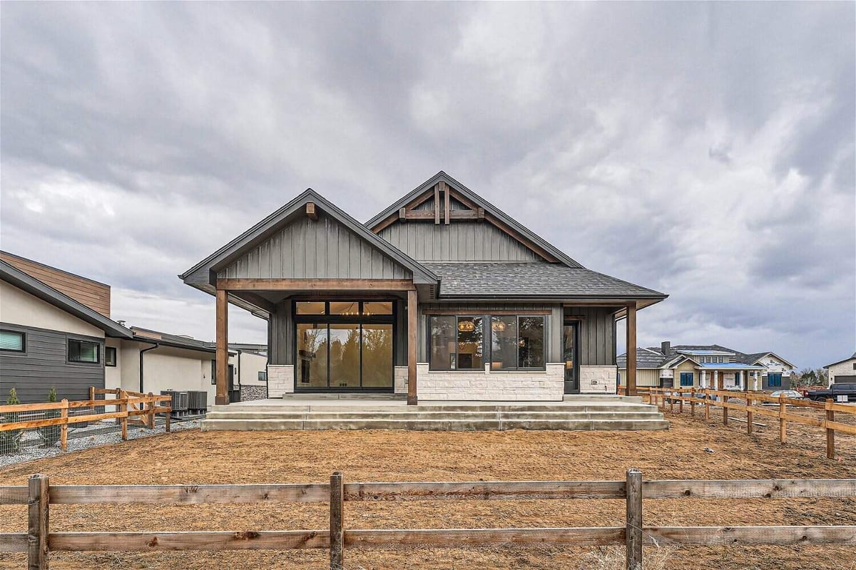 Exterior rear view of a custom home with a wooden boundary-fenced backyard, a project by Sheffield Homes in Westminster, CO