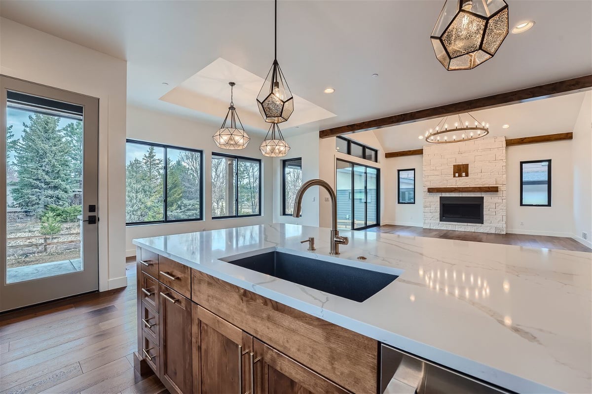 Kitchen island featuring a marble countertop, a faucet, and cabinets in a home kitchen by Sheffield Homes in Westminster, CO