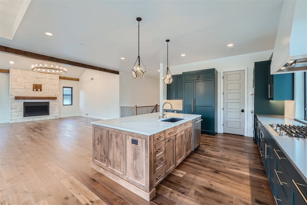 Kitchen island featuring drawers and wooden base, and a rear counter with stove fixtures, by Sheffield Homes, Westminster, CO