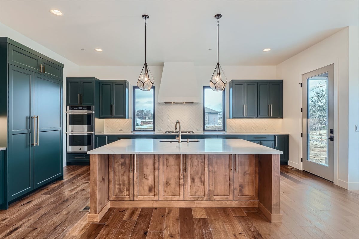 Kitchen with a central island, closets and cabinets for storage and light fixtures by Sheffield Homes in Westminster, CO