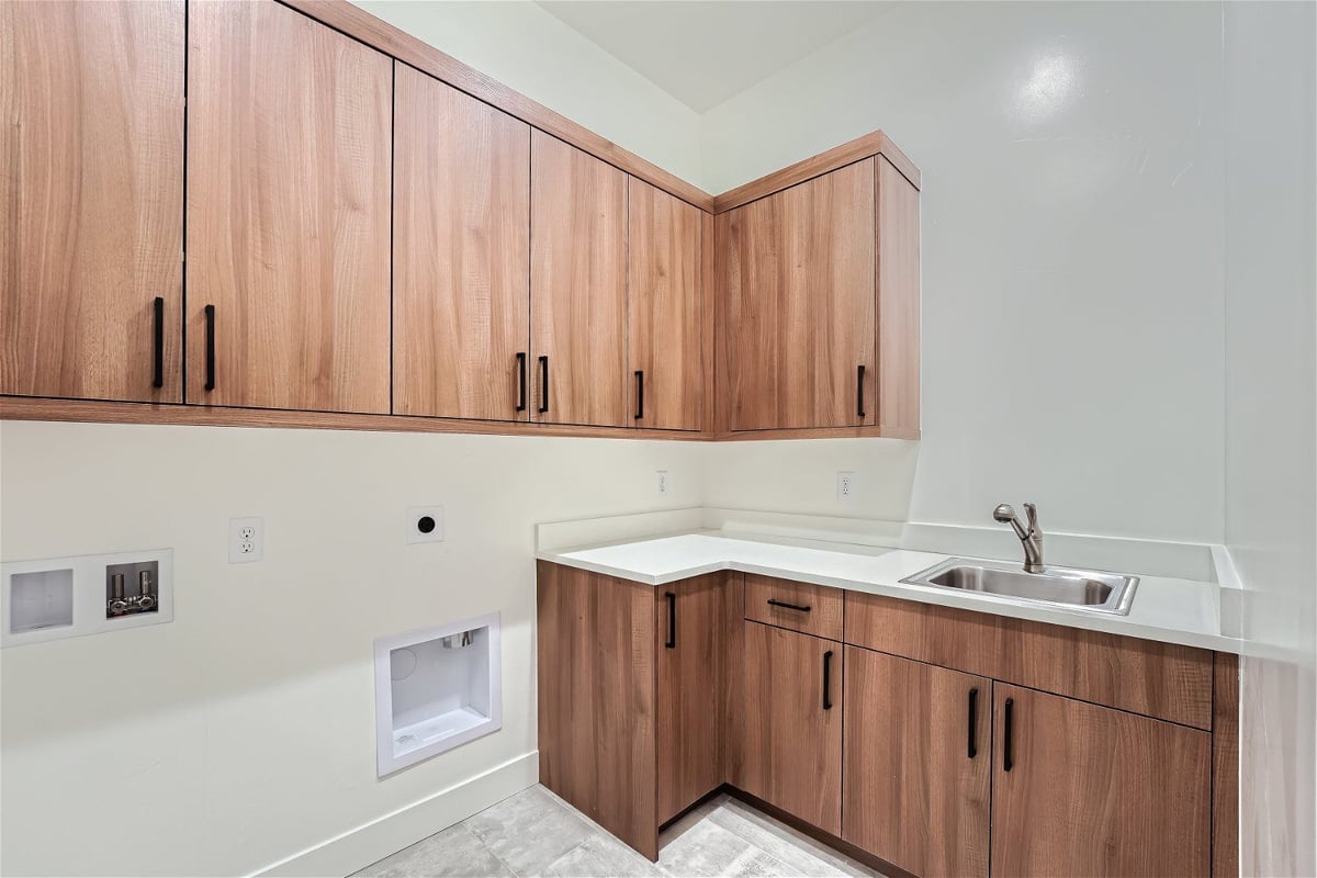 Laundry room with various counter cabinets and wall closets for storage, by Sheffield Homes in Westminster, CO