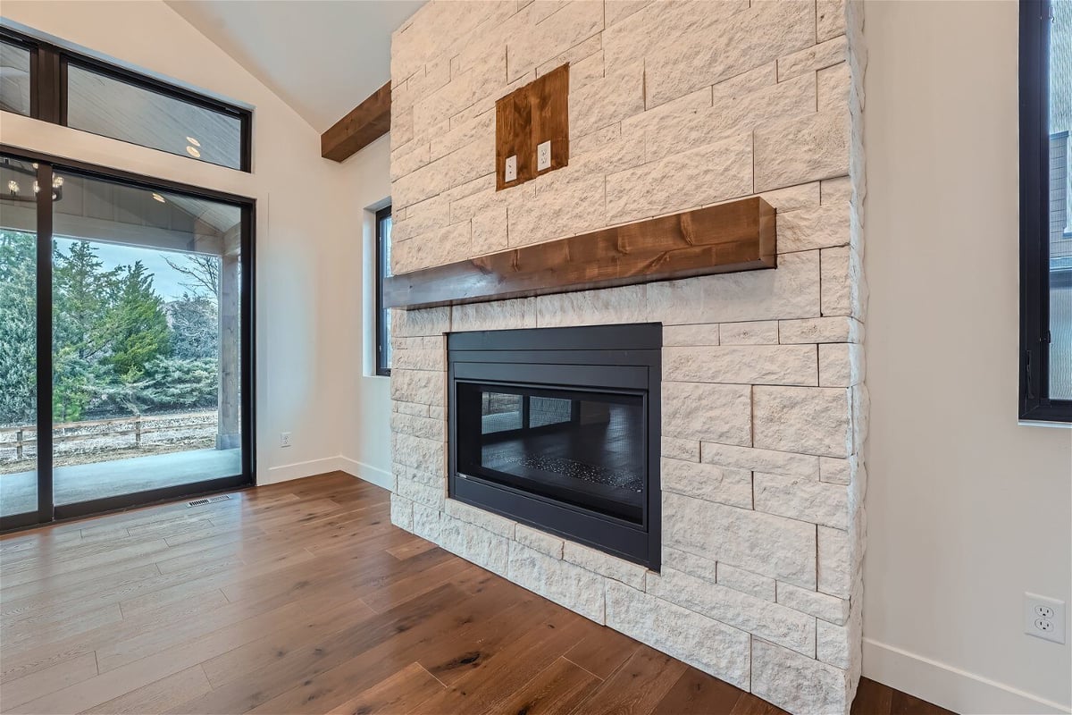 Living room with a featured wall and a mounted fireplace with a transparent cover in a Sheffield Homes home, Westminster, CO