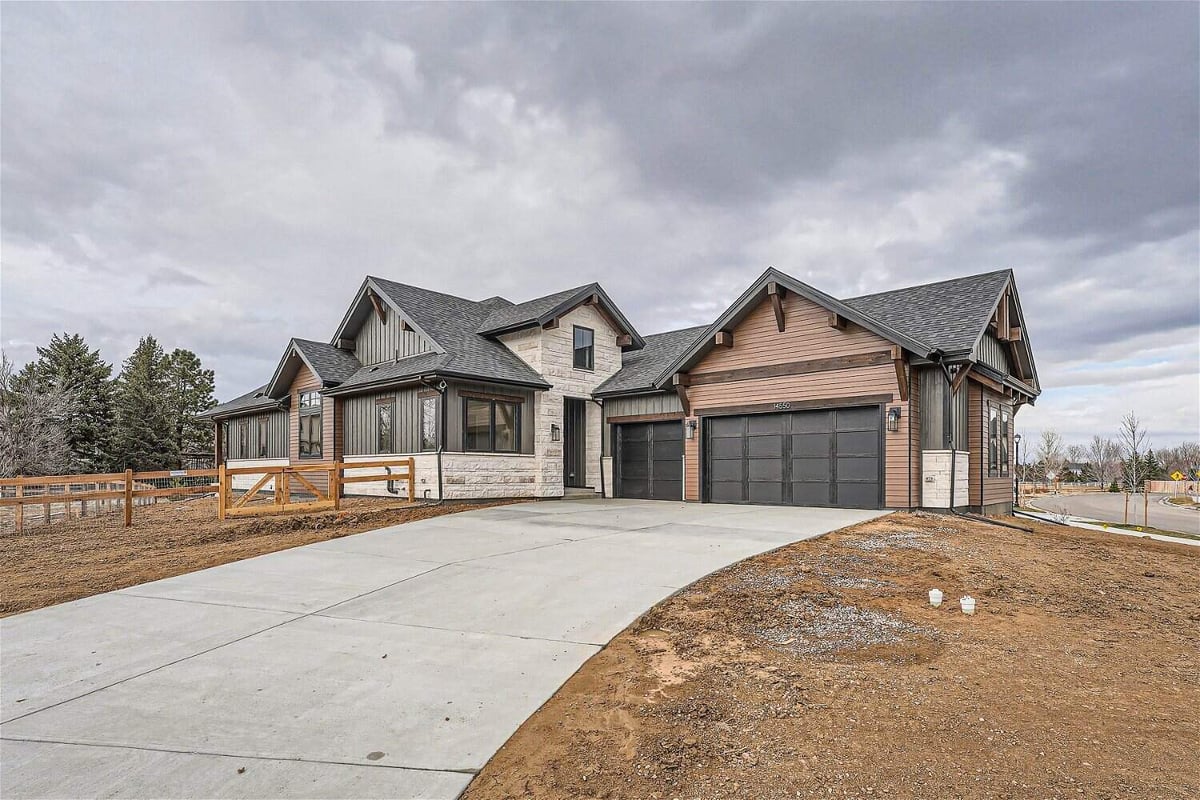 Low-angle daylight exterior front of a custom home with a yard, garage, and a driveway, by Sheffield Homes, Westminster, CO