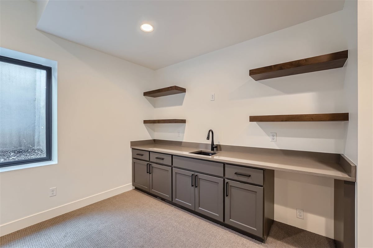 Lower-level wetbar with a sink faucet, and base drawers with wall shelves in a Sheffield Homes home in Westminster, CO