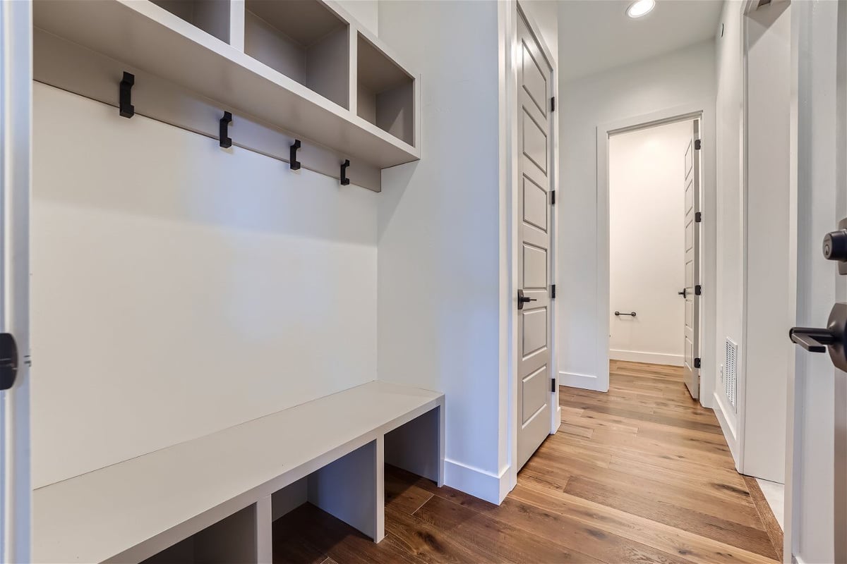 Mudroom with storage slots for footwear and cloth hanging hooks in a Sheffield Homes home in Westminster, CO