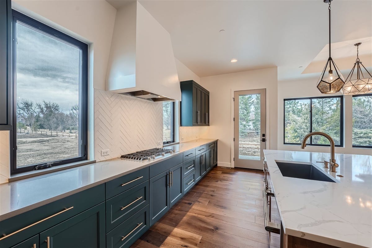 Open kitchen with cabinetry, an extractor hood, and a central island in a Sheffield Homes home in Westminster, CO