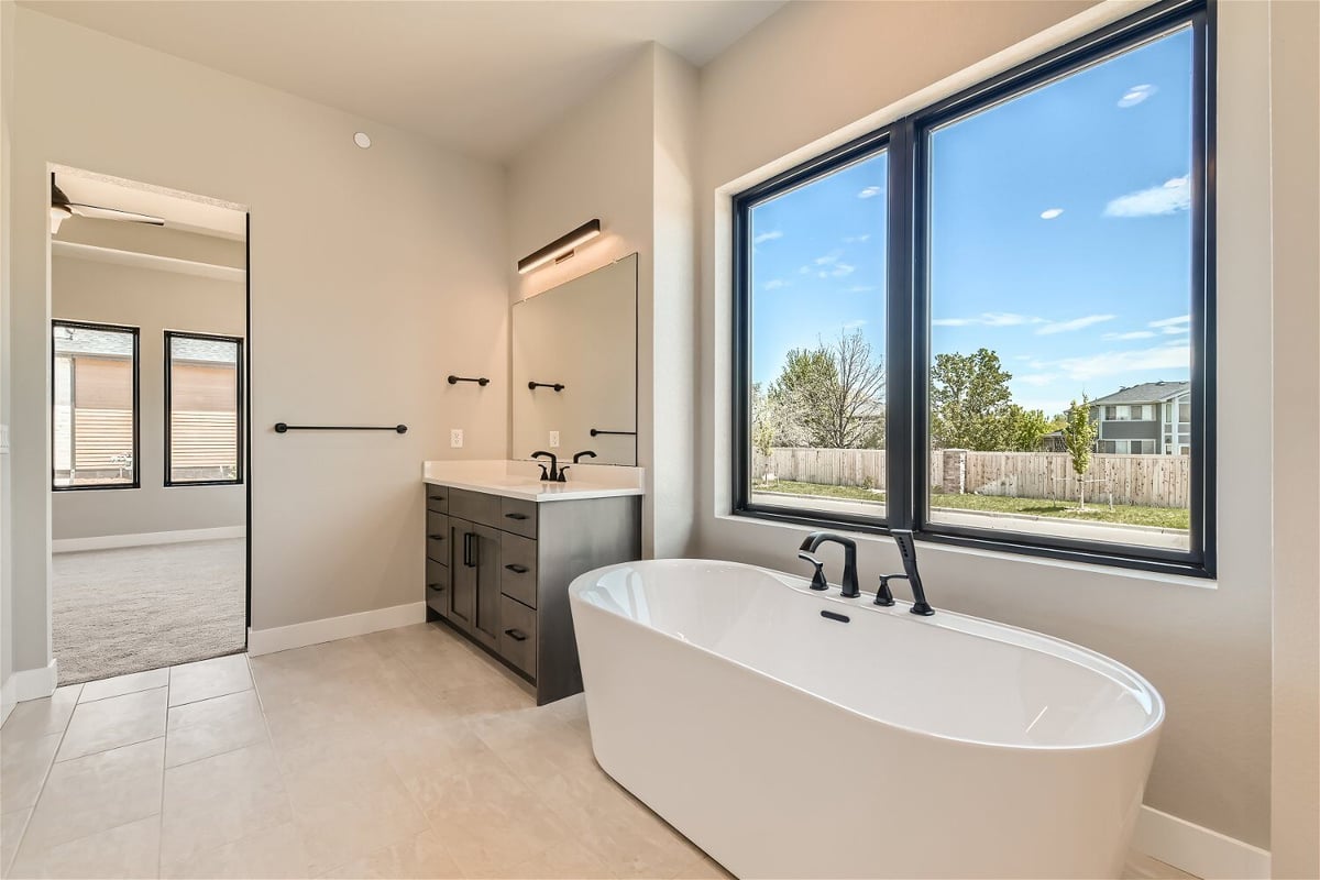 Bathroom with a freestanding tub, a vanity, and a large sliding window in a Sheffield Homes home in Westminster, CO