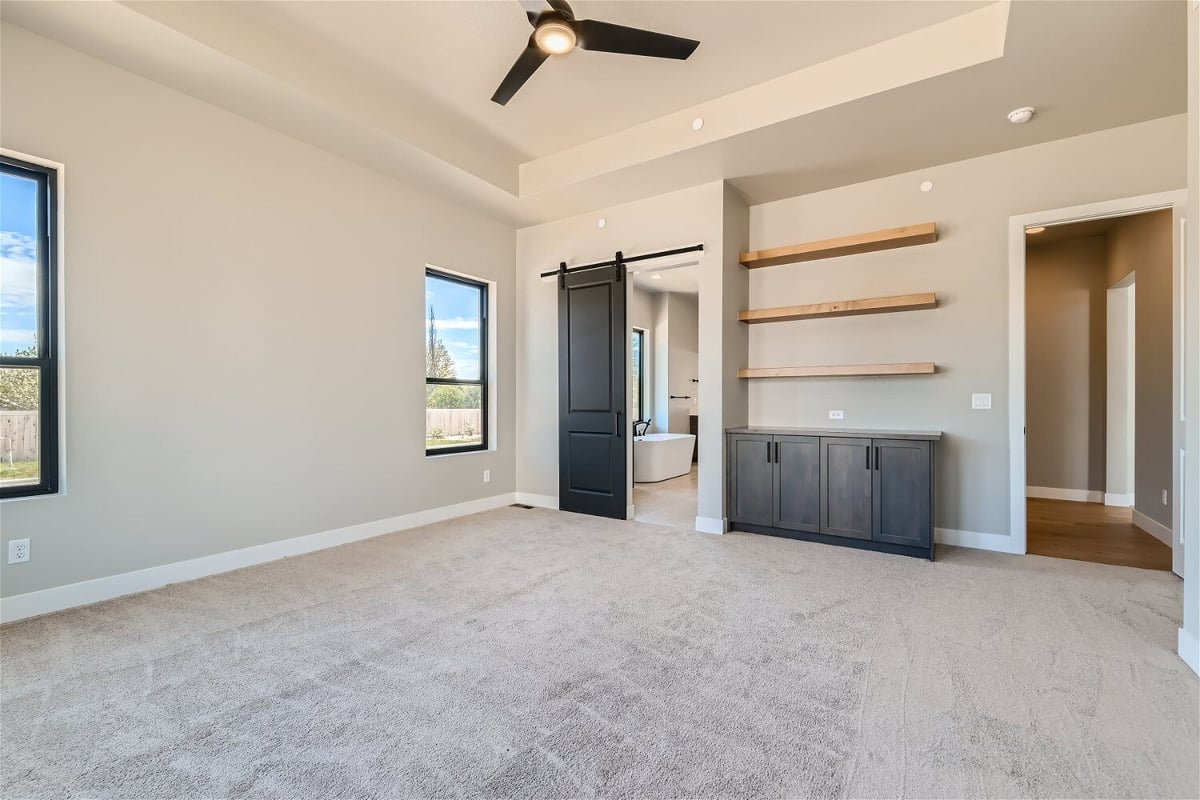 Bedroom with carpet flooring, multiple windows, and a side dresser with a wall shelf, by Sheffield Homes in Westminster, CO