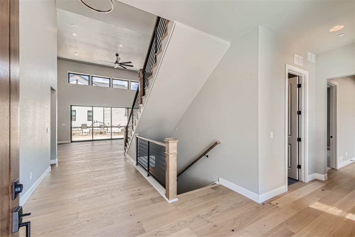 Bright foyer with vinyl flooring and a view of the staircase in a custom home by Sheffield Homes in Westminster, CO