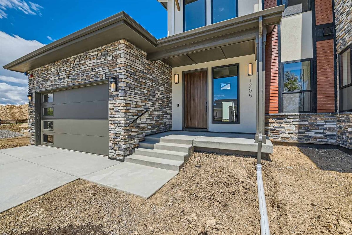 Exterior front entrance of a custom home with a door, accessed by a few steps, by Sheffield Homes in Westminster, CO