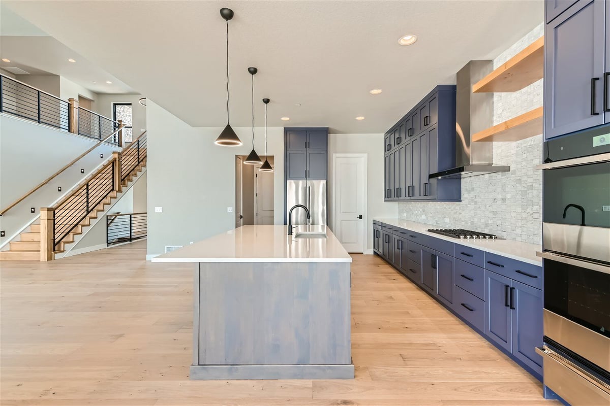 Kitchen featuring an island, rear stove counter with cabinetry, and appliances, by Sheffield Homes in Westminster, CO