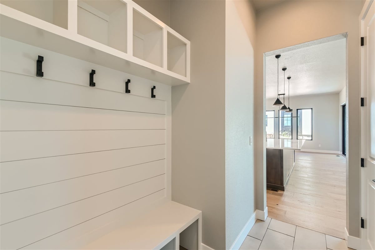 Mudroom with white wooden storage slots and cloth hooks in a Sheffield Homes home in Westminster, CO