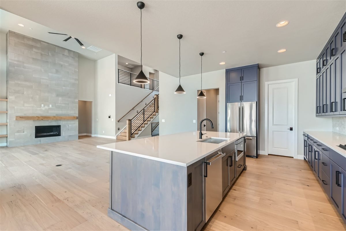 Open kitchen with an island, rear counter with cabinetry, and steel appliances in a Sheffield Homes home in Westminster, CO