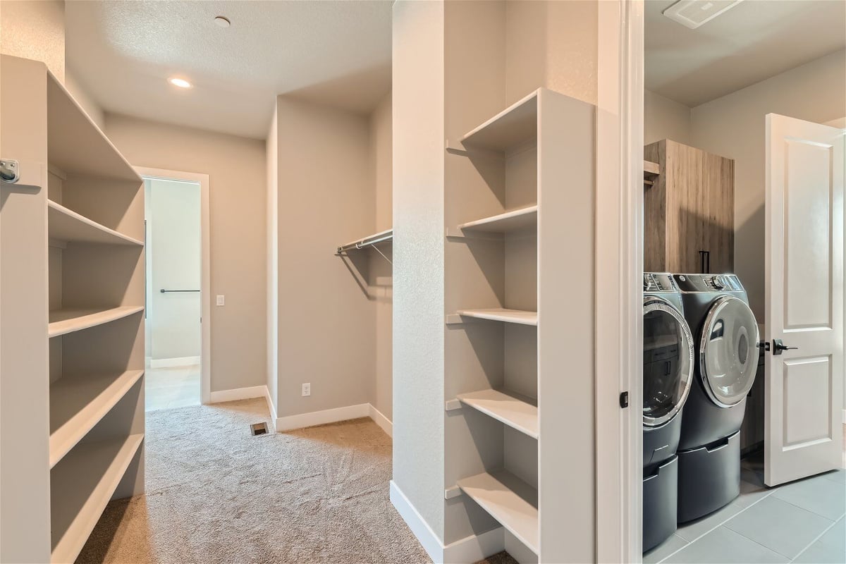 Spacious white wooden closet with the primary bedroom next to the laundry room of a Sheffield Homes home in Westminster, CO