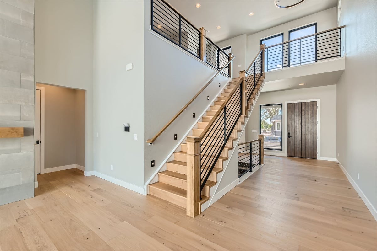 Wooden stairways with railing and metal fence in the living room of a Sheffield Homes home in Westminster, CO