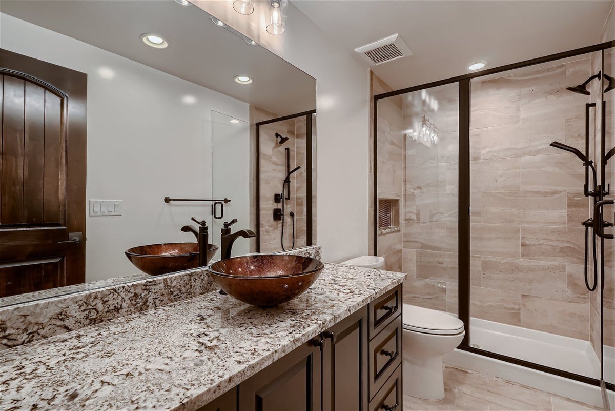 Bathroom with a granite countertop vanity, toilet, and shower enclosure in a Sheffield Homes home in Westminster, CO