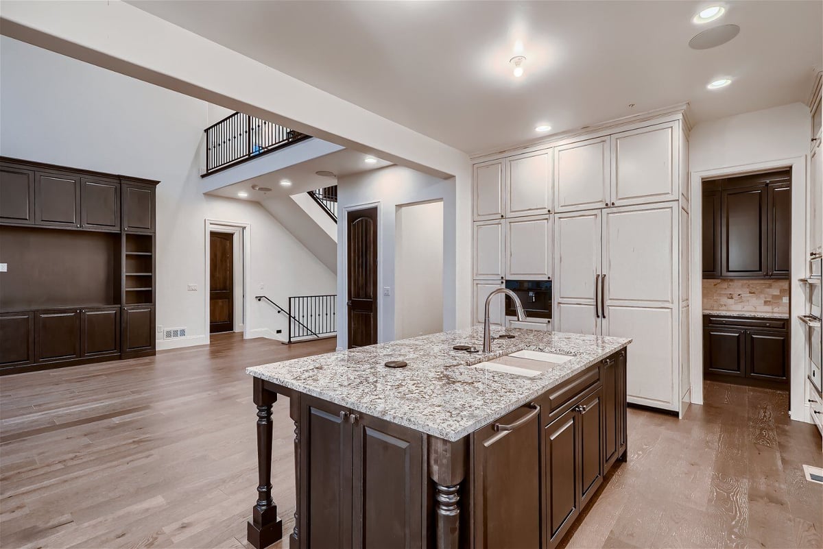 Kitchen featuring a vintage-style island with granite countertop and a faucet, by Sheffield Homes in Westminster, CO
