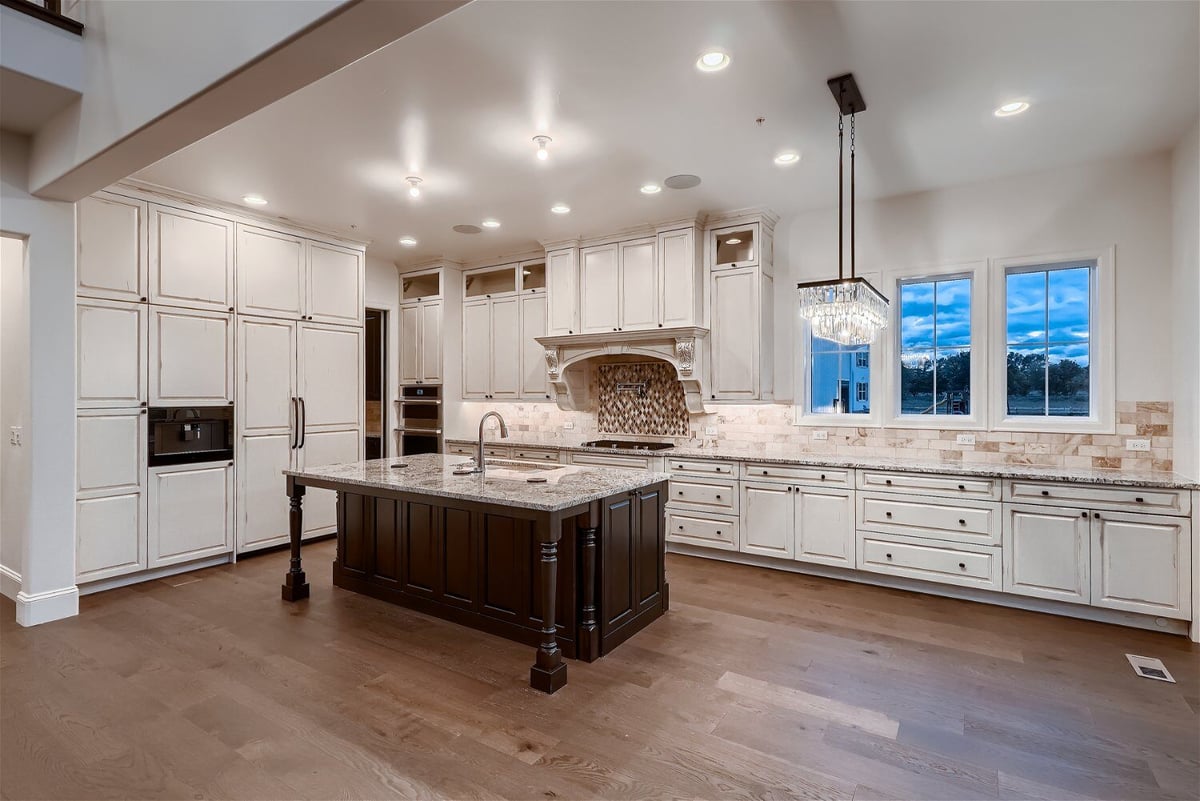 Kitchen featuring a vintage-style island, sleek modern cabinetry, and elegant lighting, by Sheffield Homes in Westminster, CO