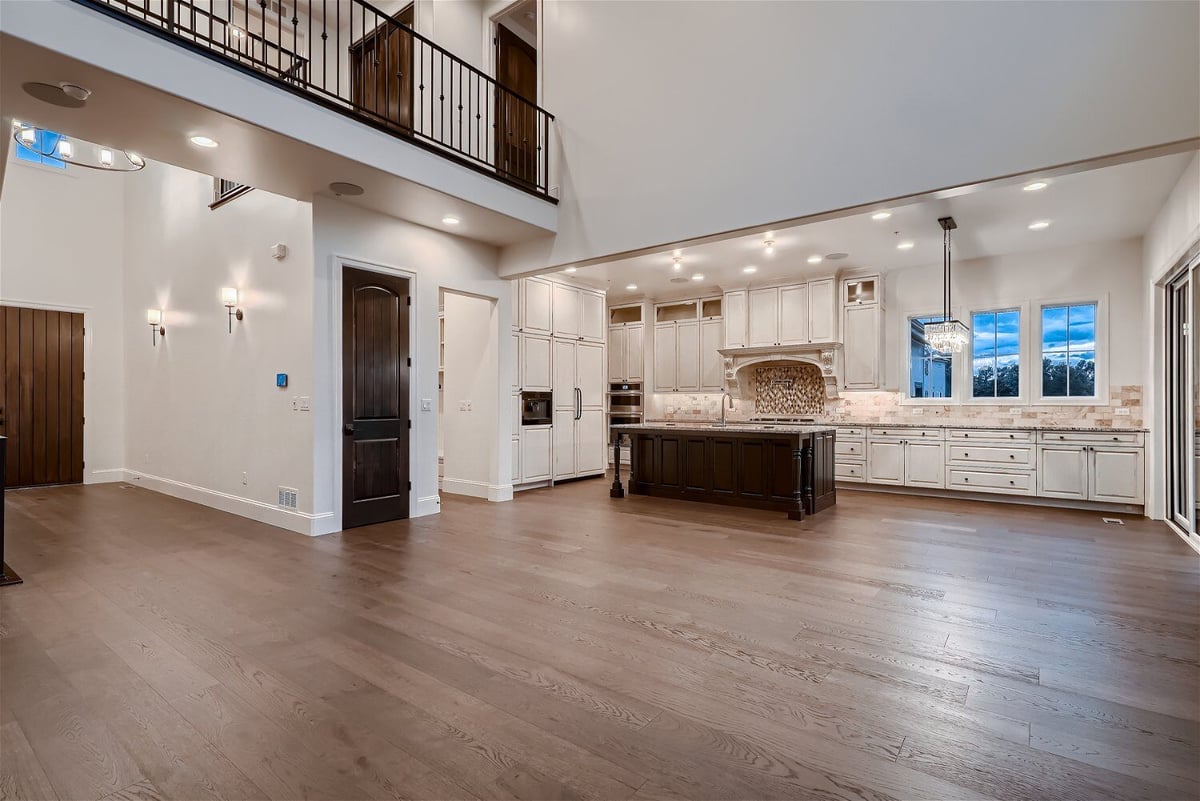 Living room with wood texture flooring and a modern open kitchen in a Sheffield Homes home in Westminster, CO