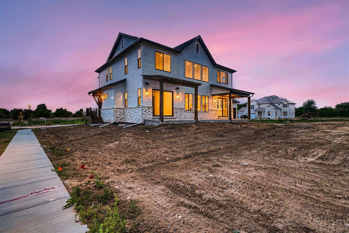 Long exterior rear view of a large custom home with a spacious backyard, built by Sheffield Homes in Westminster, CO