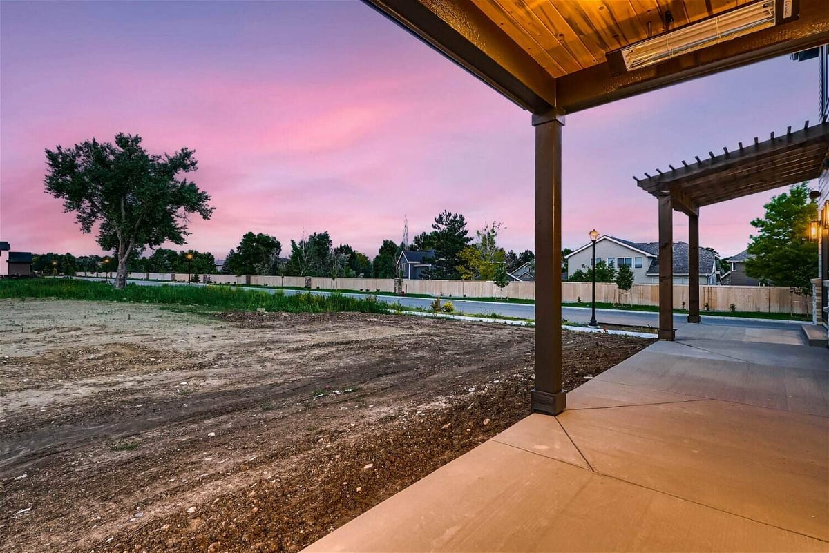 Patio with a wooden hood and pillars offering expansive outdoor views from a Sheffield Homes home in Westminster, CO